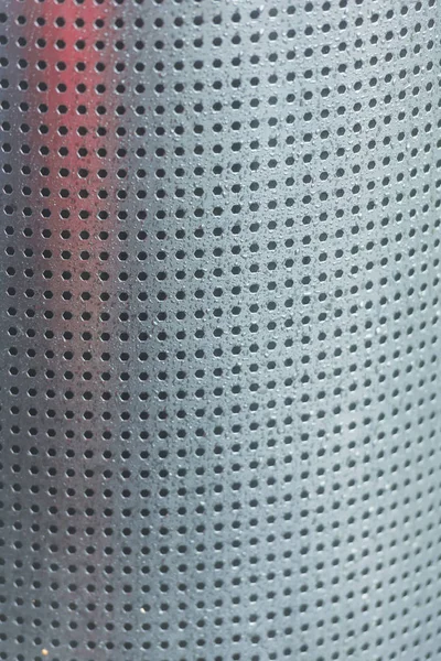 Perforated metal. Many holes in the iron sheet. Gray perforated texture. Black dots on gray background