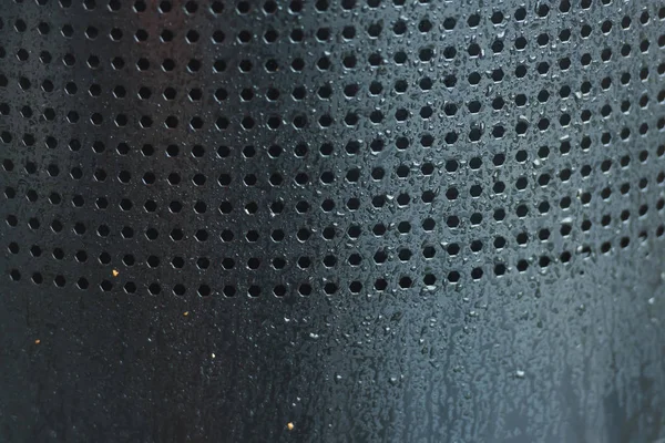Perforated metal. Many holes in the iron sheet. Black perforated texture. Black dots on gray background