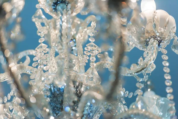 Crystal chandelier against the blue ceiling. The interior of the room. Decorative crystal chandelier.