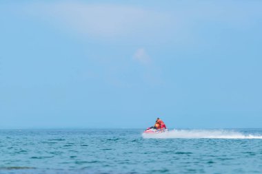Bir jet ski üzerinde denizde yüzen adam. Karadeniz. Kırım'dinlenme. Su ulaştırma araçları üzerinde turuncu yaşam ceketli çocuk.