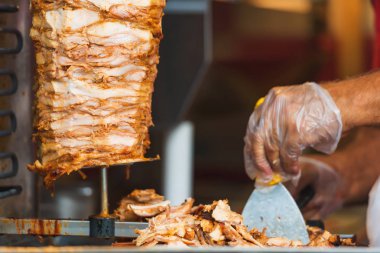 Bir şiş için Shawarma et. Kavrulmuş et. Eldiven rosto kesilmiş parçalar üzerinde olan bir erkek. Kuzu Izgara. Gıda hazırlama.