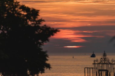 Bir bulutlu gökyüzü günbatımı. Tekne yüzer. Karadeniz üzerinde bekletin. Akşam yürüyüş boyunca gezinti.