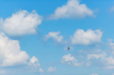 Mavi gökyüzü uçan helikopter. Hava Taşımacılığı. Helikopter bulutlu gökyüzünde uçar. Açık renk Rotorcraft.