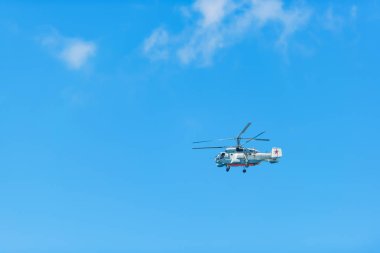 Mavi gökyüzü uçan helikopter. Hava Taşımacılığı. Helikopter bulutlu gökyüzünde uçar. Açık renk Rotorcraft.