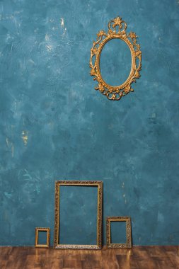 Mavi duvar zemin üzerine altın büyük çerçeve. Dekoratif unsur. Resim çerçevesi Vintage altın kaplama. Vintage Fotoğraf bölge.