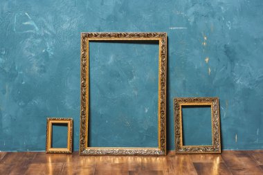 Mavi duvar zemin üzerine altın büyük çerçeve. Dekoratif unsur. Resim çerçevesi Vintage altın kaplama. Vintage Fotoğraf bölge.