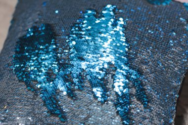 Çift taraflı payetler. Mavi ve gümüş payetler. Payetler ile şık yastık.