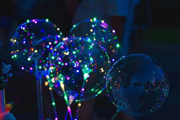Transparent balloon with garland inside. Air glowing balls. Magical Balloon at the fair.