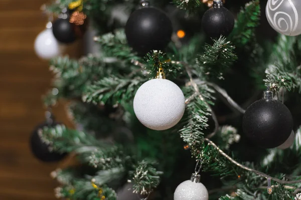 Christmas decoration in gold, black and white colors. Black and white christmas tree. Modern New Year\'s scenery. Black and white frosted balls.
