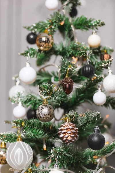 Christmas decoration in gold, black and white colors. Black and white christmas tree. Modern New Year's scenery. Black and white frosted balls.