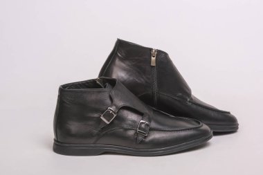 Siyah erkek botlar. Beyaz bir arka planda erkek ayakkabıları. Siyah Keşiş kayış