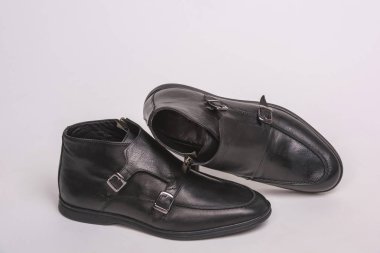 Siyah erkek botlar. Beyaz bir arka planda erkek ayakkabıları. Siyah Keşiş kayış