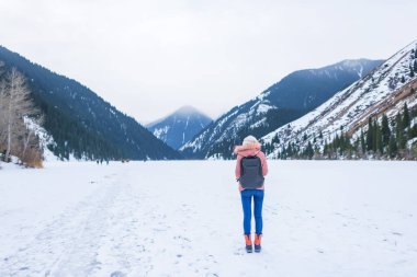 Dağ dağlar göl buz kaplı. Göl kışın kız. Kazakistan'ın Lake Kolsay. Kazakistan Cumhuriyeti Kış Turizm.