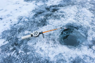 Buz balıkçılık bir dağ gölü. Donmuş gölün yüzeyinde Balık tutma. Buz balık tutmak için ekipmanlar. Buz üstünde balık oltası ile delik.