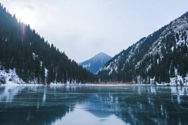 Kışın dağ gölü. Göl buz kaplı dağlarda. Kazakistan'ın göl Kolsay.