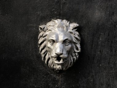 Georgia'da vintage mimari. Kapıda metal aslan amblemi var. Tiflis'te yürü. Siyah arka plan üzerinde metal aslan.