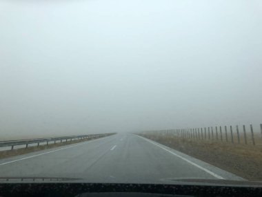 Yol gezisi. Ülke parkuru. Arabanın ıslak ön camı. Yağmurlu ve sisli hava.