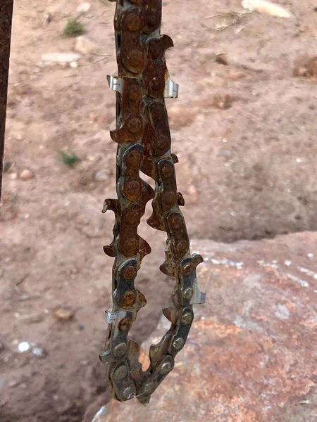 Rusty chain from a chainsaw on the ground. The metal part of the chainsaw. Rust on the metal surface.