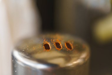 Baharat için delikli metal bir kavanoz. Baharat kavanozu. Mutfakta tabaklar. Metal kapaktaki delikler.