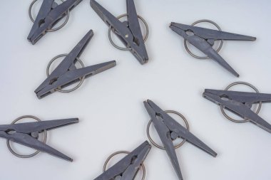 Siyah plastik giysi beyaz arka planda mandal. Giysiler kurutmak için clothespins. Işık arka planda gri clothespins deseni.