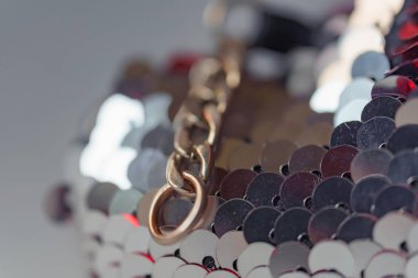 Çift taraflı payetler ile anahtar zinciri. Bilateral payetler dokusu. Kırmızı ve gümüş çift taraflı payetler. Kumaş üzerinde zincir.