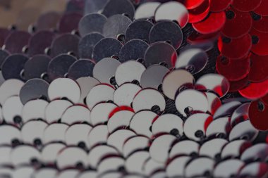 Bilateral payetler dokusu. Kırmızı ve gümüş çift taraflı payetler. Ölçeklerle kumaş. Dikiş için payetler ile malzeme.