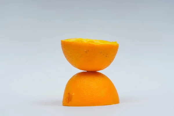 Orange skin after fresh squeezed juice. Half an orange without pulp on a white background. Waste from fresh orange juice.
