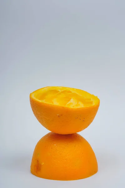 Orange skin after fresh squeezed juice. Half an orange without pulp on a white background. Waste from fresh orange juice.