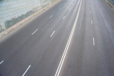 Gri asfalt yolun dokusu. Pistte beyaz işaretler var. Yolculuk. Büyük geniş yol.