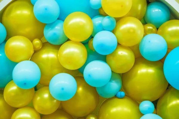 Interior decoration with helium balloons. Children\'s holiday. Balls blue and yellow. Composition of helium balloons.