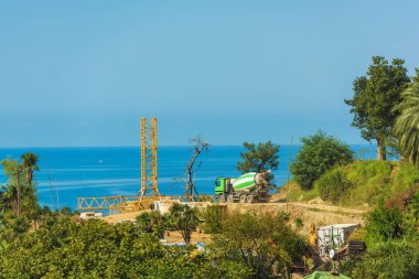 Karadeniz'de inşaat çalışmaları. Georgia'da dinlenin. Kova ile sarı inşaat traktör. Batum'da traktör kıyıda.