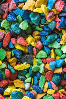 Bahçe dekorasyonu için çok renkli çakıl taşları. Parkta renkli çakıl. Sarı, mavi, kırmızı ve yeşil küçük taşlar. Çakıl yolunun dokusu.