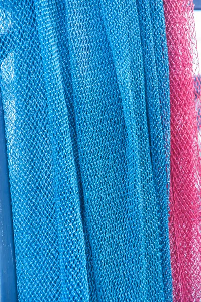 Multicolored mesh fabric. The perforated texture of the fabric. Fishing net. Transparent textiles.