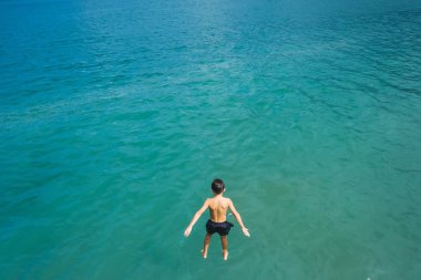 Çocuk denize atladı. Karadeniz 'de dinlenin. Su mavi. Batum 'da Karadeniz sahili. Gürcistan 'da dinlenme.