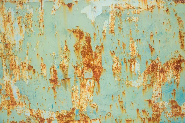 Peeling paint on the metal surface. Corrosion of metal on the car. Rusty painted metal texture.
