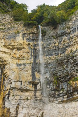 Okatse nehrinin kanyonunda Kinchkha Şelalesi. Georgia 'da dinlenin. Imereti bölgesinde yüksek şelale. Yeşil ağaçlar ile dağın kayalık çıkıntıları.