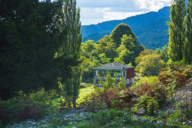 Dağlarda doğada ahşap ev. Georgia 'da dinlenin. Kutaisi 'de yürü. Yeşil ağaçların bir arka planda Vintage ev.