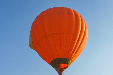 Mavi gökyüzü arka plan turuncu renk sıcak hava balonu. Balon Festivali'nde Sıcak Hava Balonları. Kazakistan'da Balon Festivali. Gündüz balonlarla uçmak.