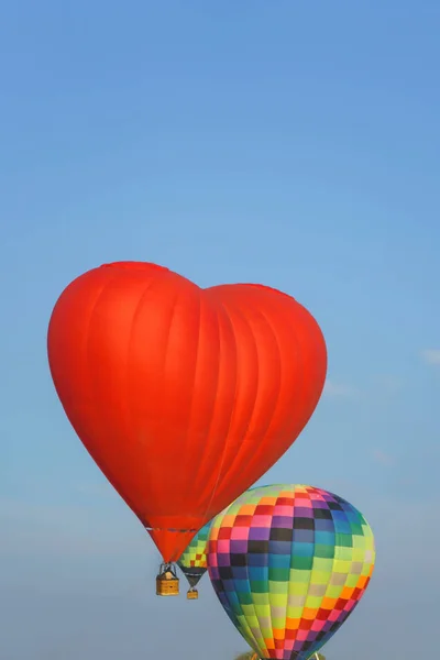 红色热气球的形状在蓝天上是心脏 热气球在气球节 哈萨克斯坦的气球节 下午乘坐气球飞行 — 图库照片
