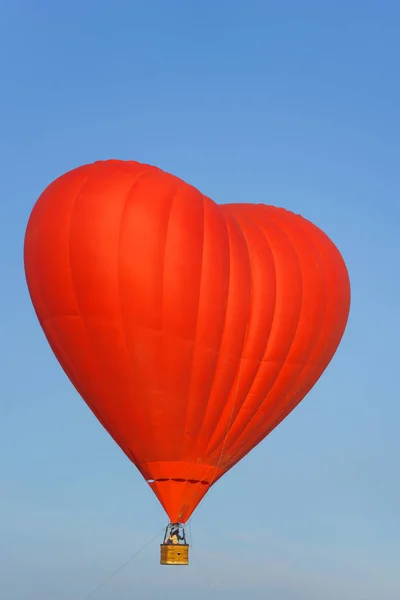 红色热气球的形状在蓝天上是心脏 热气球在气球节 哈萨克斯坦的气球节 下午乘坐气球飞行 — 图库照片