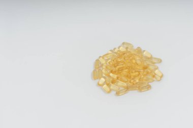 Beyaz arka planda sarı şeffaf kapsüller. Beslenme takviyeleri omega-3, omega-6 ve omega-9. Vejetaryen balık yağı hapları.