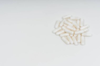 Beyaz arka planda beyaz hap kapsülleri. Jelatin kapsüller şeklinde beslenme takviyeleri. Hyaluronik asit kapsülleri vegan selüloz kaplamasında.