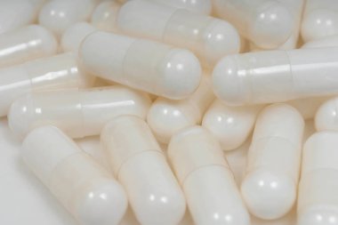 Beyaz arka planda beyaz hap kapsülleri. Jelatin kapsüller şeklinde beslenme takviyeleri. Hyaluronik asit kapsülleri vegan selüloz kaplamasında.