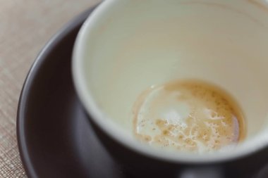 Kapuçinodan kirli bir fincan. Kahve içecekleri için koyu sofra takımı. Fincanın dibindeki bir kahve içeceğik. Kirli. 