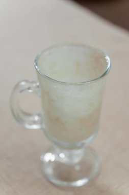 Bir fincan soğuk kahve içeceği. Kahve içecekleri için şeffaf sofra takımı. Fincanın dibindeki bir kahve içeceğik. Kirli bulaşıklar.