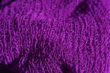 Örme koyu mor kumaş doku. Menekşe örülmüş soyut arka plan. Leylak bez closeup.