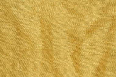 Açık sarı kumaş dokusu. Bej tekstil malzemesi dokusu. Sarı-yeşil eşarp.
