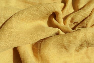 Açık sarı kumaş dokusu. Bej tekstil malzemesi dokusu. Sarı-yeşil eşarp.