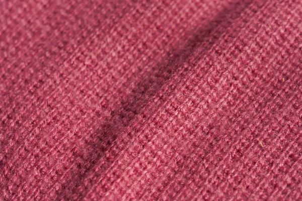 Texture of knitted pink fabric. Pink abstract background. Light pink thick winter fabric