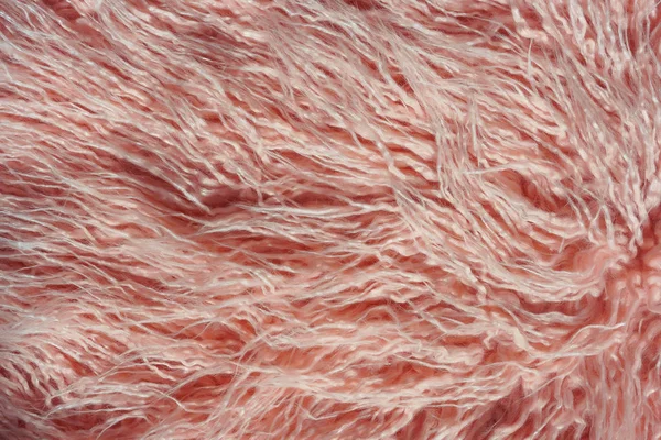 Texture of pink fur. Pink abstract background. Light pink faux fur like merino skin.